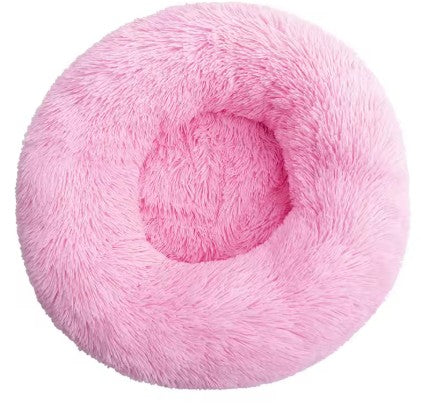 Pink fluffy donut-shaped pet bed on a white background